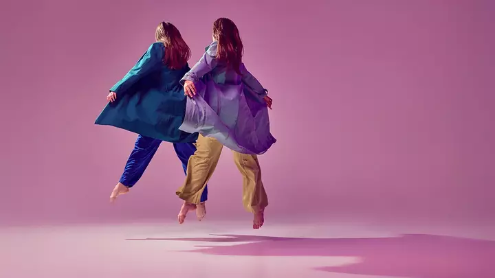 Two contemporary dancers frozen in the air as if they were fyling 